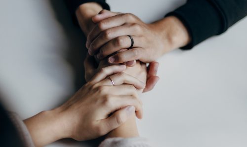 Hands holding eachother, offering support.